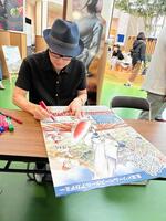 初披露した野球教室告知のポスターにサインする平松伸二さん