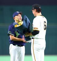 坂本から花束を受け取る石川（左）＝撮影・石井剣太郎