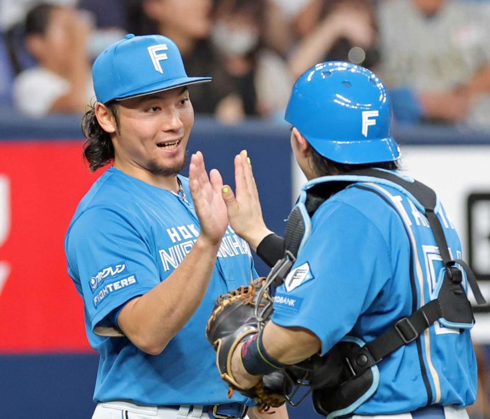 　１０勝目を挙げ田宮（右）とタッチを交わす伊藤（撮影・立川洋一郎）