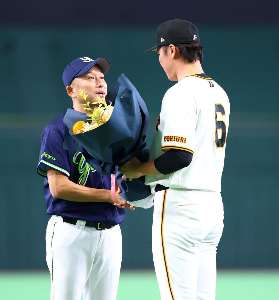 坂本から花束を受け取る石川（左）＝撮影・石井剣太郎