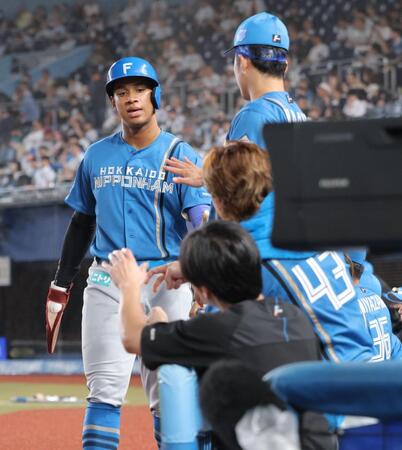 ５回、郡司の適時内野安打で生還し、ナインとタッチを交わす万波（撮影・西岡正）