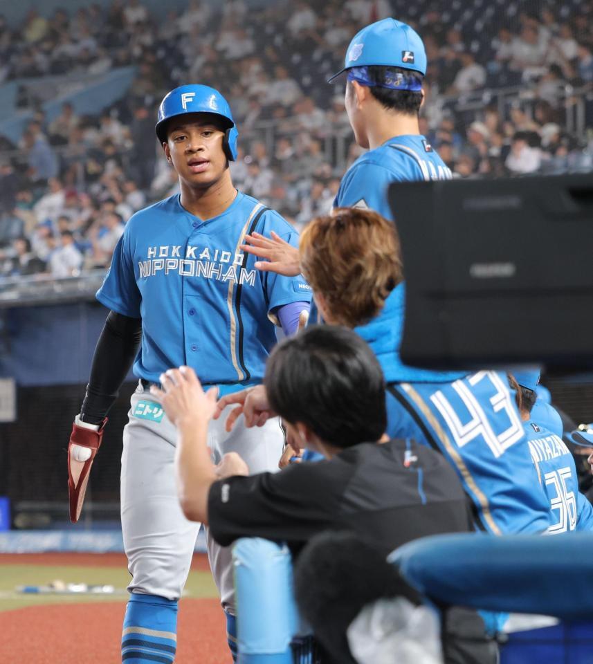 ５回、郡司の適時内野安打で生還し、ナインとタッチを交わす万波（撮影・西岡正）