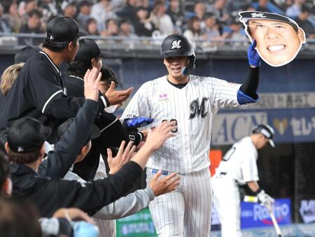 ４回、同点ソロを放ち、角中勝也の顔面プリントを持ちながら、ナインとタッチを交わす井上（撮影・西岡正）
