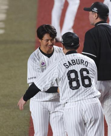 サブロー監督と握手をする唐川（撮影・佐々木彰尚）