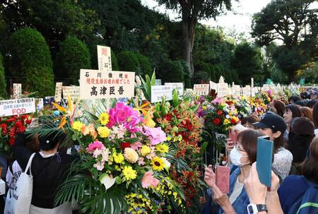 ヤクルト・石川雅規に贈られた花々と写真に収めるファンたち＝明治神宮球場（撮影・中島達哉）