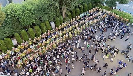 石川に贈られたたくさんの花々と写真に収めるファンたち（撮影・中島達哉）
