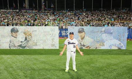 記念ボードを背に記念撮影に応じるヤクルト・石川雅規＝明治神宮球場（撮影・中島達哉）