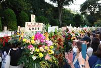 ヤクルト・石川雅規に贈られた花々と写真に収めるファンたち＝明治神宮球場（撮影・中島達哉）