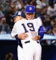 メンバー表を交換し、池山監督（手前）と抱擁する井上監督（撮影・中島達哉）