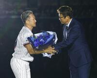 古田敦也氏（右）から花束を受け取るヤクルト・石川雅規＝明治神宮球場（撮影・中島達哉）