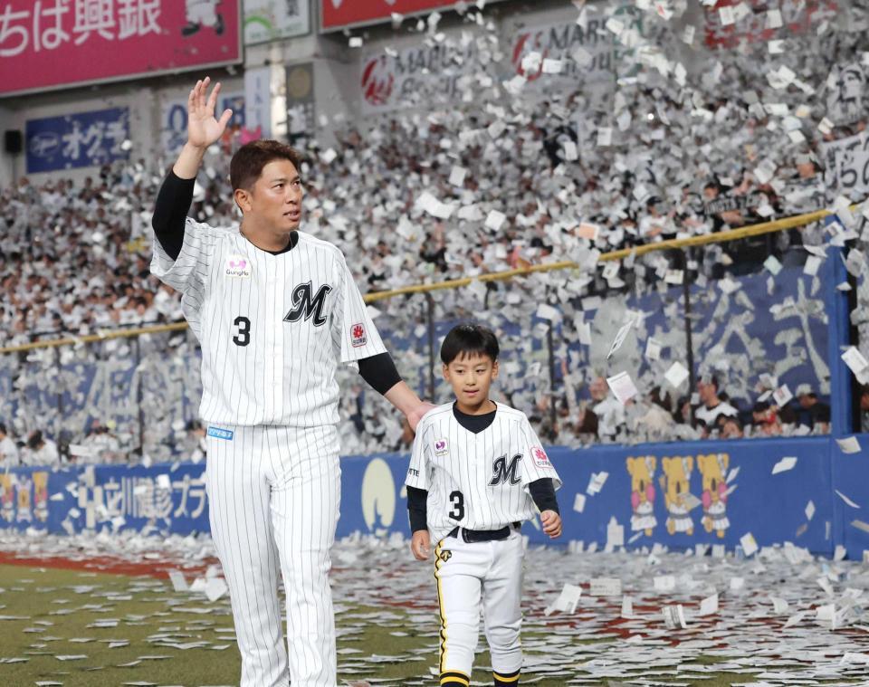 　次男の稜汰くんと紙吹雪の中を歩く角中（撮影・西岡正）