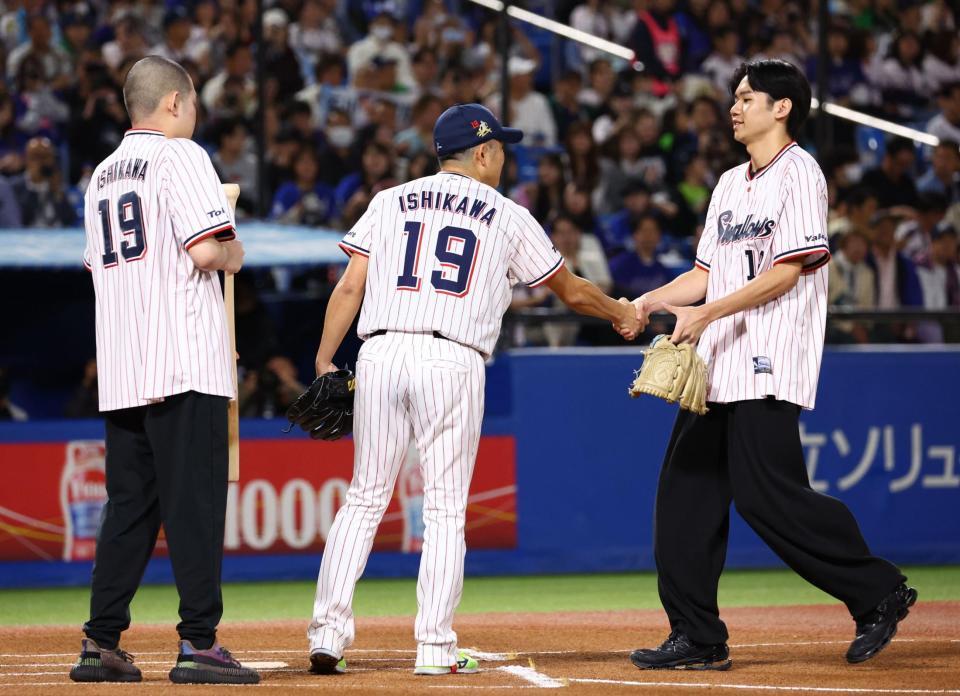 ファーストピッチセレモニーで投球する息子の大耀さん（右）とバッター役を務めた息子の栄寿さん（左）を迎える石川（撮影・中島達哉）