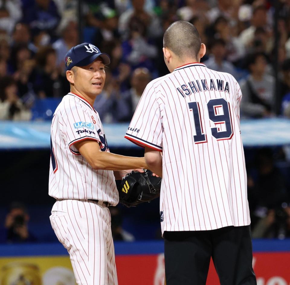 ファーストピッチセレモニーでバッター役を務めた息子の栄寿さん（右）と握手を交わす石川（撮影・中島達哉）
