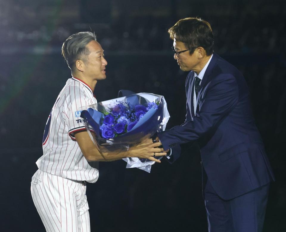 古田敦也氏（右）から花束を受け取るヤクルト・石川雅規＝明治神宮球場（撮影・中島達哉）