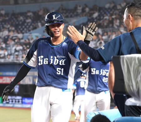 ９回、小島の適時打で生還し、ナインとタッチを交わす西川（撮影・西岡正）