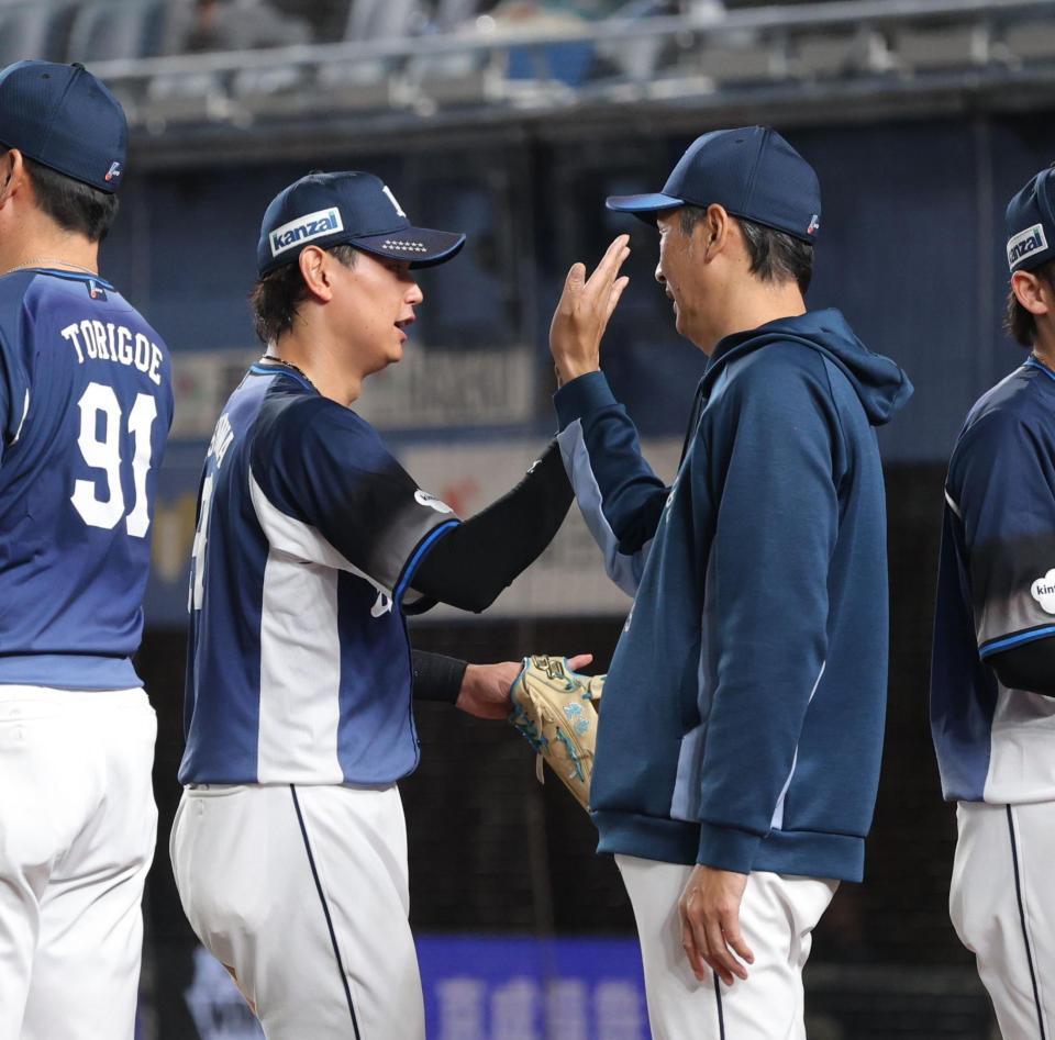 ロッテに勝利し、ナインとタッチを交わす西口監督（右）＝撮影・西岡正