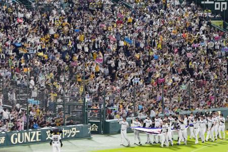　優勝セレモニーで場内一周する阪神の選手らと声援を送るファン＝６日、甲子園球場