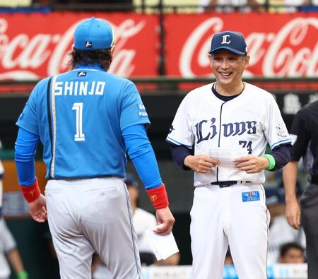 新庄監督（左）とのメンバー表交換に向かう西口監督（撮影・中島達哉）