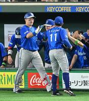 １回、先制ソロを放ち、先発の東（右）とタッチを交わす牧