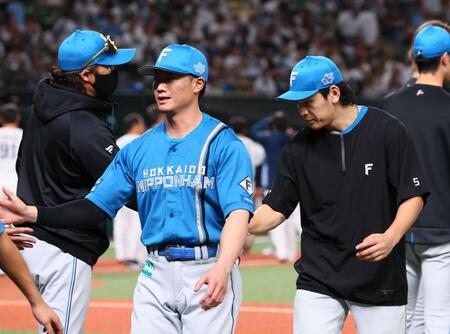 野村（右）らナインを迎える新庄監督（左）＝撮影・中島達哉
