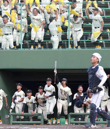 ７回、崇徳・河野拓真が適時打を放ち、喜ぶ崇徳ナインと崇徳応援団（手前右下は広陵主将・勝本晴太）＝撮影・北村雅宏