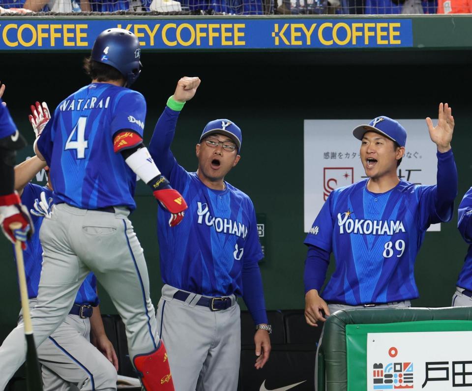 １回、先頭打者ソロを放った度会（４）を出迎える相川監督（中央）＝撮影・佐々木彰尚