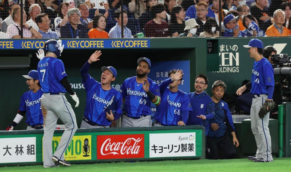 ７回、戸柱の適時打で生還した三走・佐野を出迎えるナイン（撮影・佐々木彰尚）
