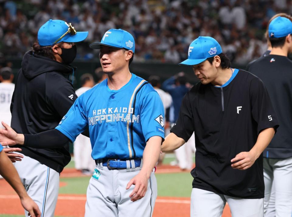 野村（右）らナインを迎える新庄監督（左）＝撮影・中島達哉