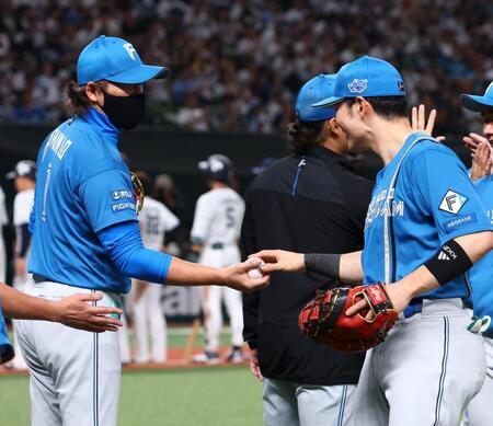 清宮幸（右）から勝利球を手渡される新庄監督（撮影・中島達哉）