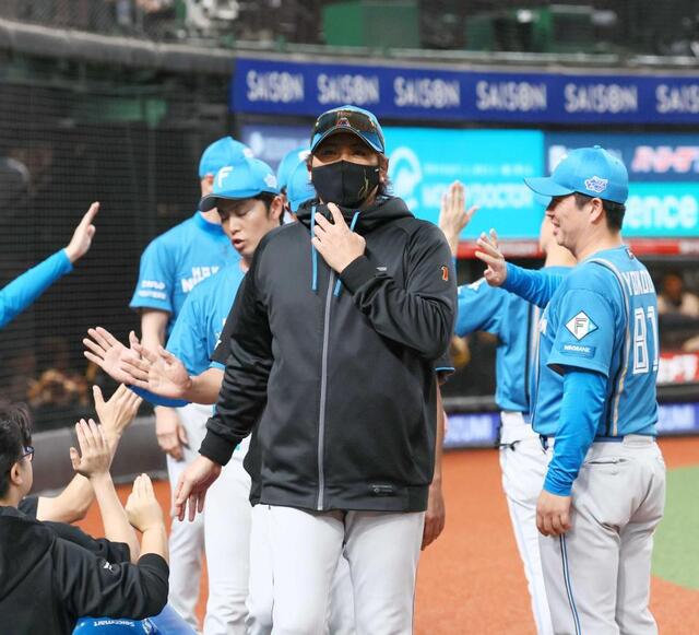　逆王手をかけ、コーチ陣とタッチを交わす新庄監督（撮影・中島達哉）