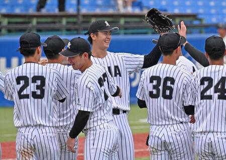 国学院大戦でノーヒットノーランを達成し、ナインとタッチを交わす亜大・川尻（中央）