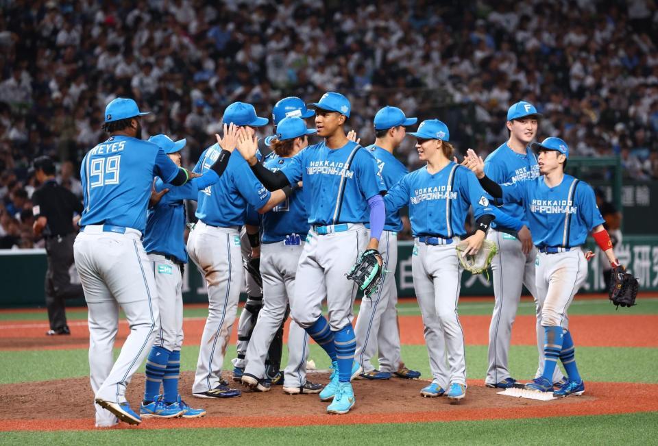 西武に勝利をあげ、タッチを交わす日本ハムナイン（撮影・中島達哉）