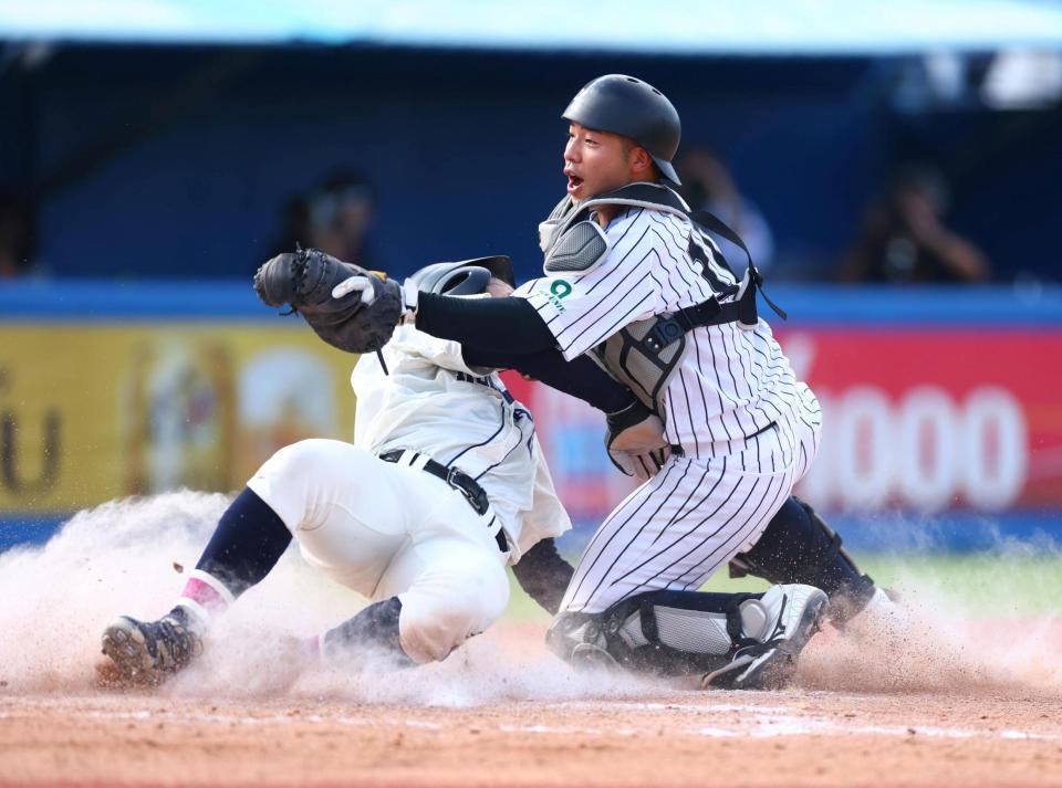 ８回、国学院大・石野蓮授の本塁生還を阻止する亜大・前嶋藍（右）＝撮影・石井剣太郎