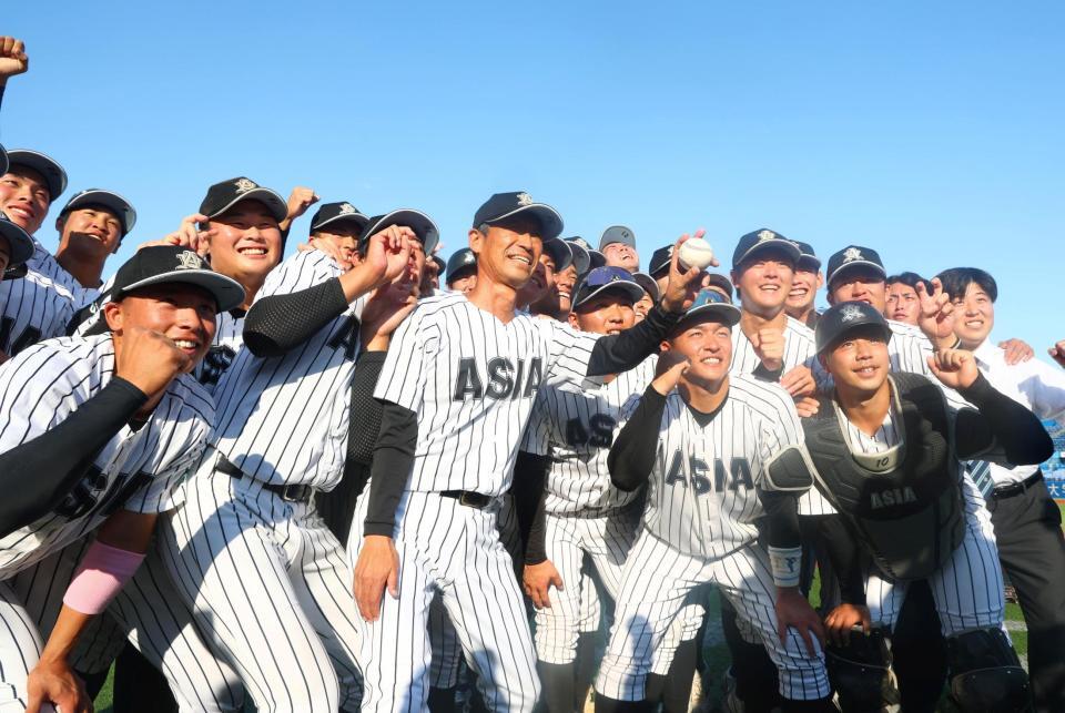 優勝を決め正村公弘監督（前列中央）のもとでポーズをとる山里宝（前列左端）、前嶋藍（前列右端）ら亜大ナイン（撮影・石井剣太郎）
