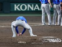 マウンドの土を拾うレイノルズ（撮影・山口登）