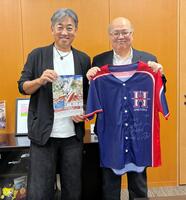 高梁市役所を表敬訪問し、野球教室告知のチラシを持つ西崎さん（左）は中山副市長（右）にサイン入りユニホームを手渡した