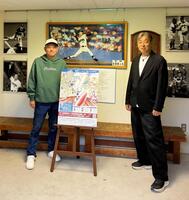 平松政次球場を訪れ、発起人代表の上野智司さん（左）とポスターと一緒に写真に収まる西崎幸広さん（右）