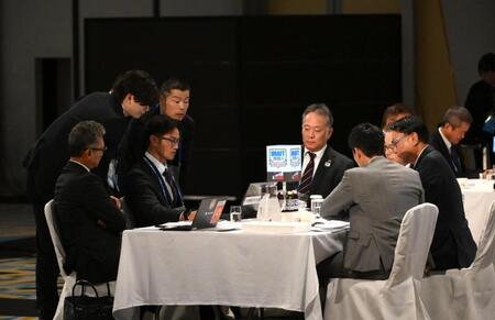６位の指名中にヤクルトのテーブルに駆けつける関係者（撮影・堀内翔）