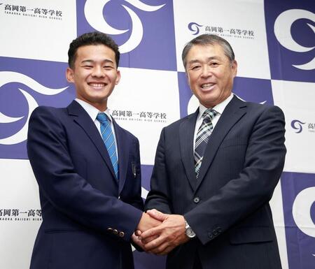 ロッテ２位指名を受け、高岡第一・村本忠秀監督（右）と笑顔で握手する前田侑大（撮影・西田忠信）