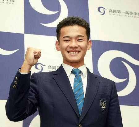 ロッテから２位指名を受け、笑顔でポーズを撮る高岡第一・前田侑大＝高岡第一高校（撮影・西田忠信）