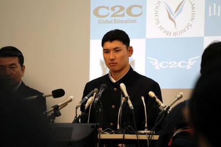 真剣な表情でドラフト会議の中継を見る山梨学院・菰田