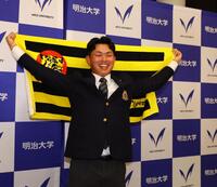 阪神からドラフト１位指名を受け、笑顔で記念撮影に応じる明大・榊原七斗（撮影・中島達哉）