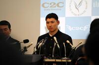 真剣な表情でドラフト会議の中継を見る山梨学院・菰田