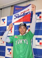 ヤクルト球団旗を手にするヤクルト１位指名の東京ガス・藤沢涼介（撮影・佐々木彰尚）