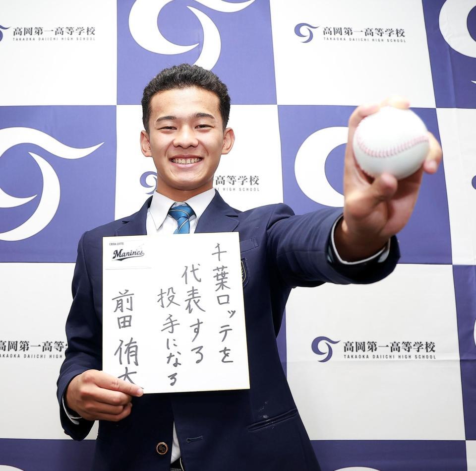 ロッテに２位指名され、色紙を手に笑顔の高岡第一・前田侑大（撮影・西田忠信）
