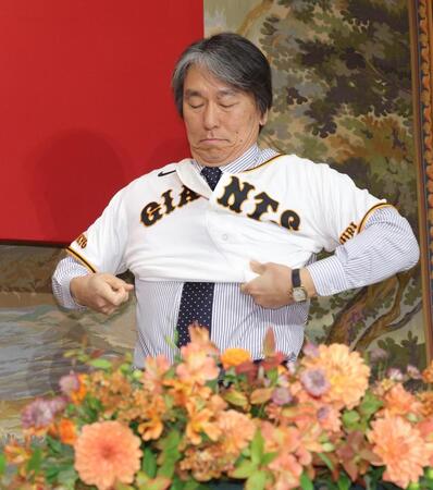 ユニホームに袖を通す松井新監督（撮影・西岡正）