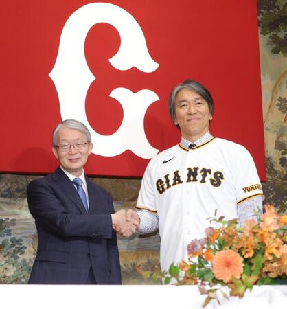 山口寿一オーナー（左）と握手する松井新監督（撮影・西岡正）