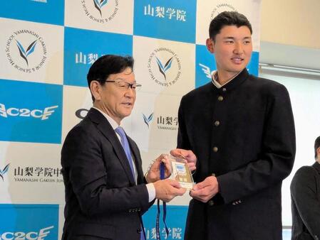 ドラフト１位指名した山梨学院・菰田（右）にドラフト会議のＩＤカードをプレゼントする日本ハム・栗山英樹ＣＢＯ