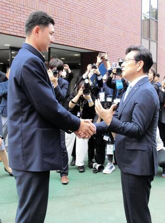 ドラフト１位指名した山梨学院・菰田（左）と握手して言葉を交わす日本ハム・栗山英樹ＣＢＯ