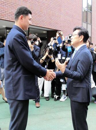 　菰田（左）と握手して言葉を交わす栗山ＣＢＯ